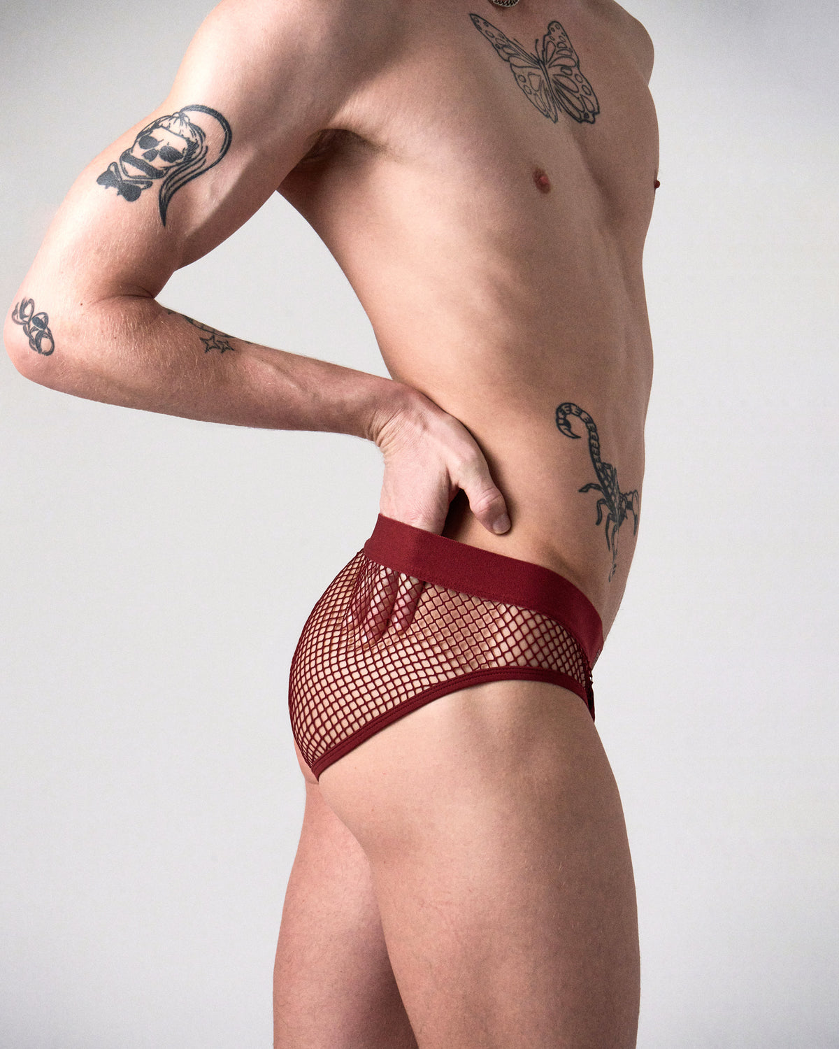Edge Net Brief en Maroon, vista lateral que muestra la malla que va de la cadera a toda la parte trasera