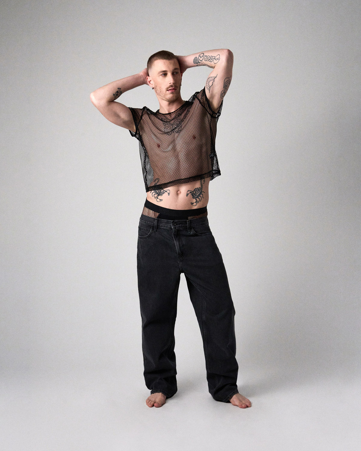 Edge Net Cropped Tee in Jet, men's sheer net crop top, full-length front view with black jeans