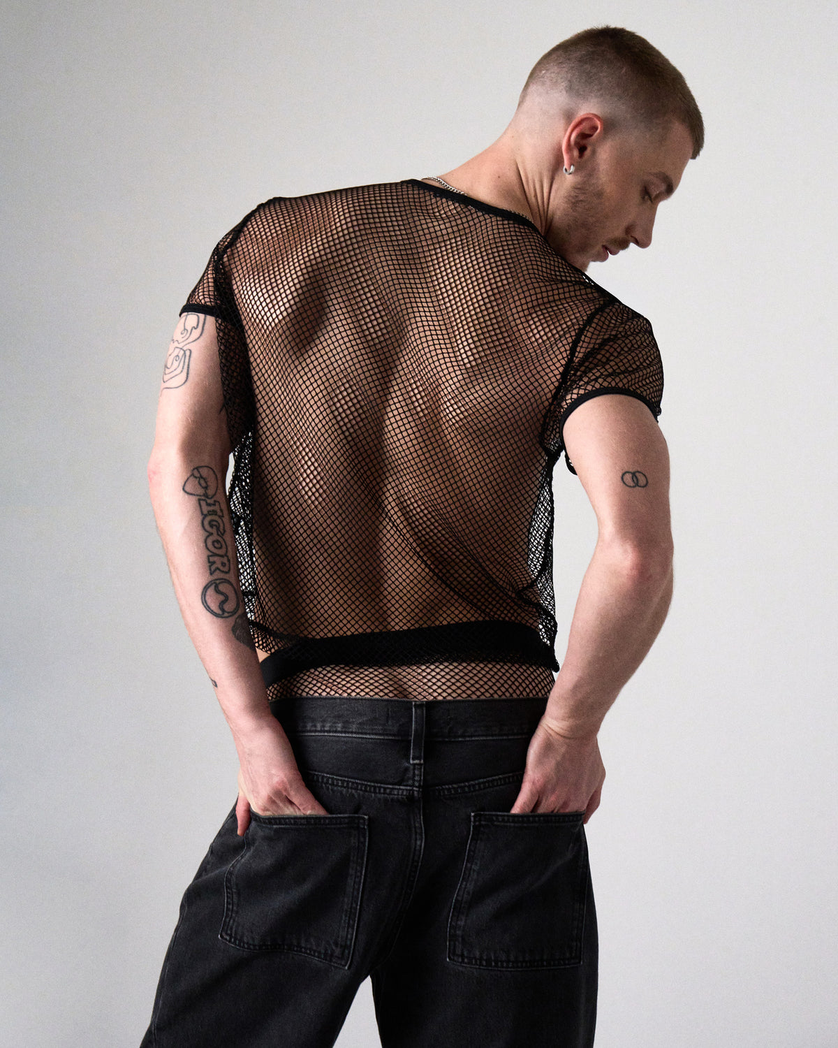 Edge Net Cropped Tee in Jet, back view with hands in jean pockets showing the sheer net back