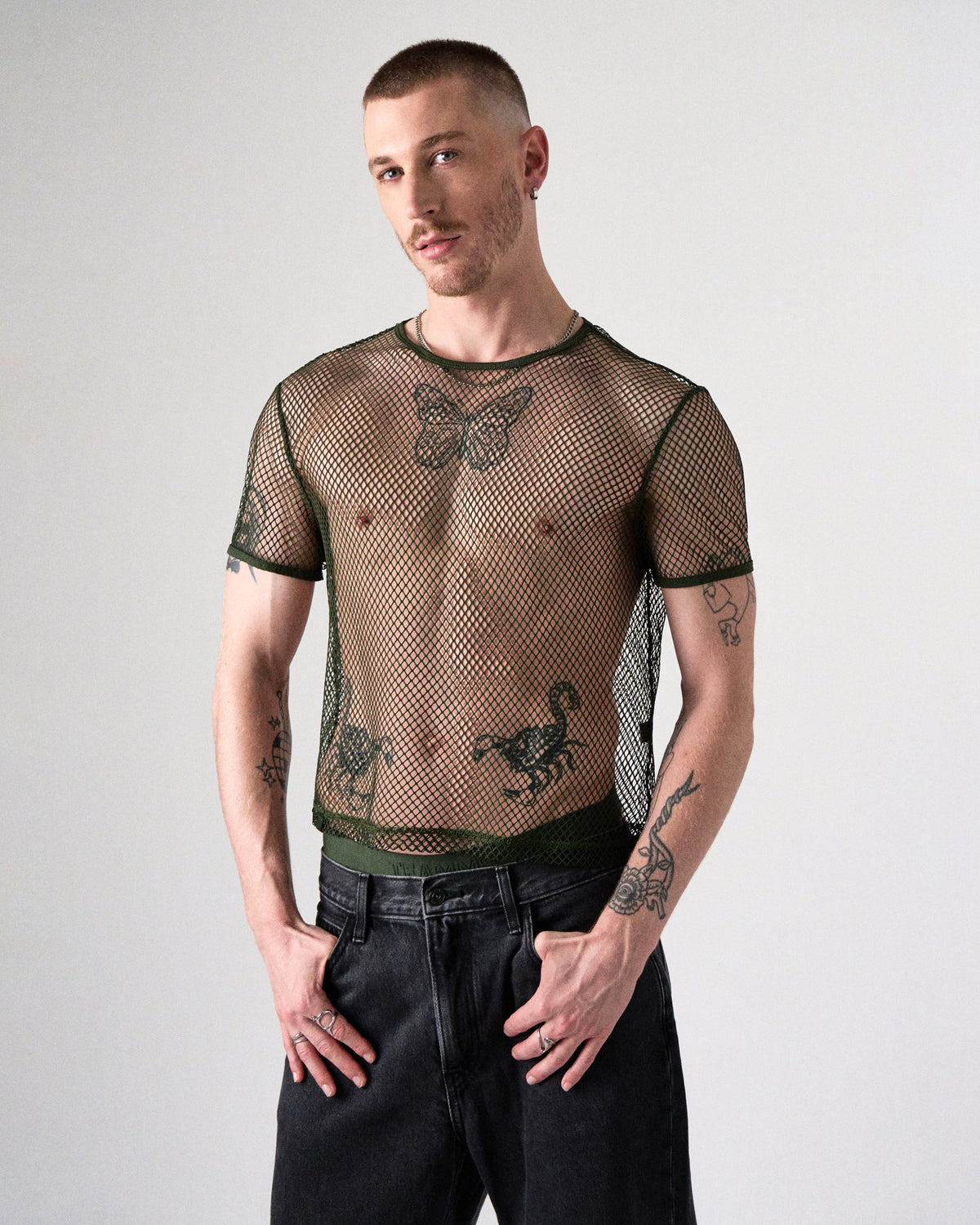 Edge Net Cropped Tee in Forest, front view on model with hands in the pockets of black jeans