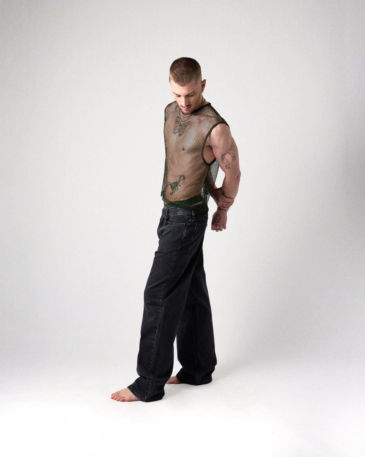 Edge Net Muscle Tank in Forest, full-length side view on model with black jeans