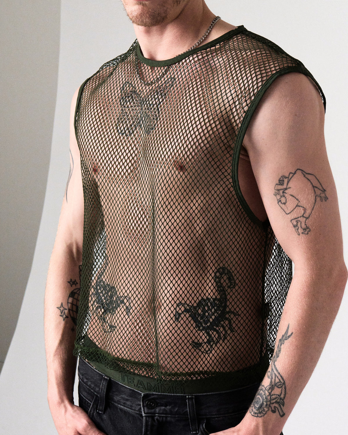 Edge Net Muscle Tank in Forest, front close-up of the full net tank worn with black jeans