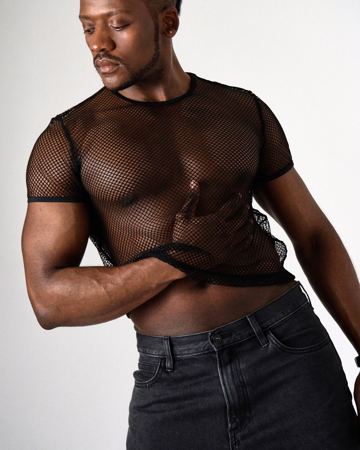 Edge Net Cropped Tee in Jet, front view on model holding the hem, worn with black jeans