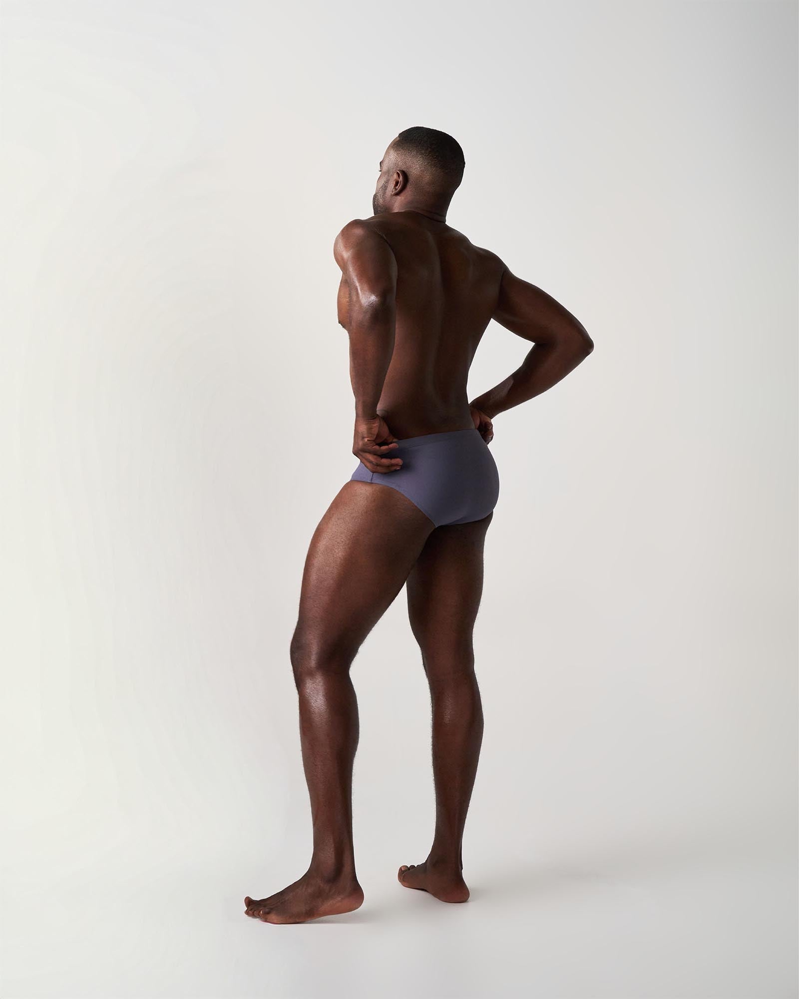 Man wearing a gray swim brief on a white background