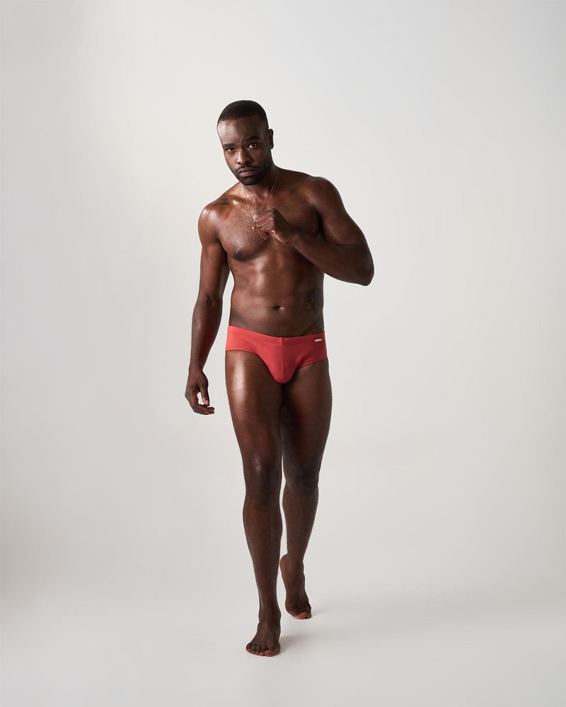 Man wearing red swim briefs on a white background